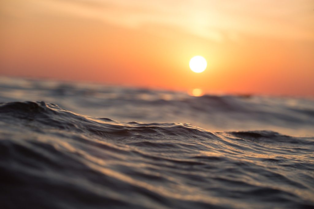 Image of waves with a setting sun (Image by Pexels from Pixabay.)