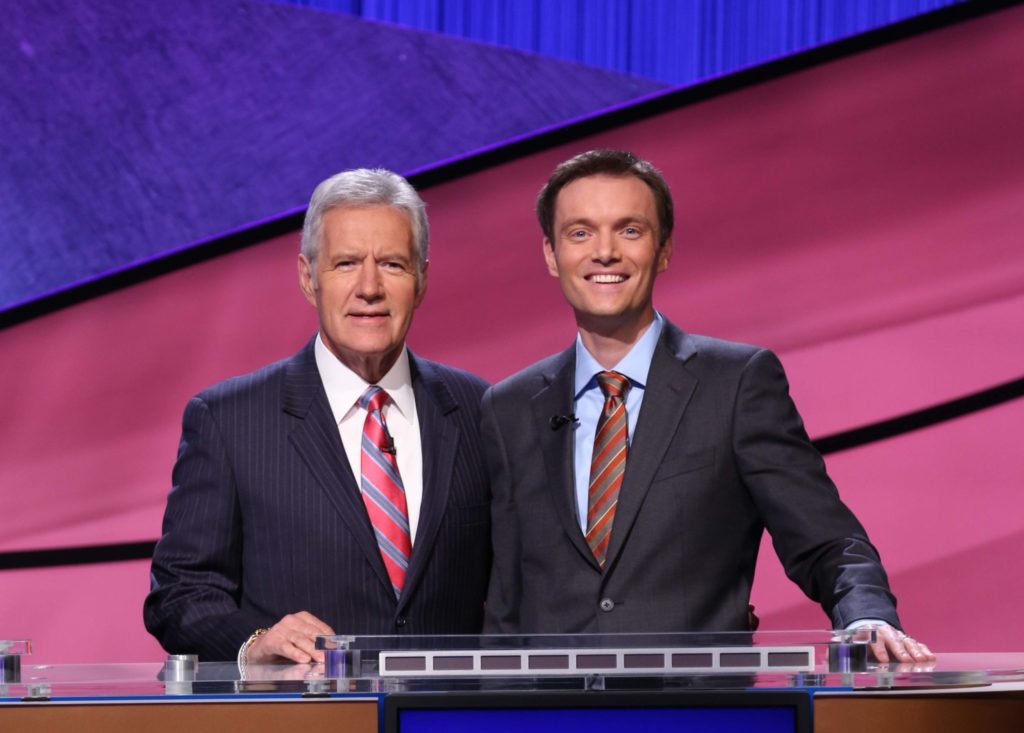 A photo of Alex Trebek from Jeopardy! and Russ Schumacher, CSU state climatologist, in front of a purple and pink background.