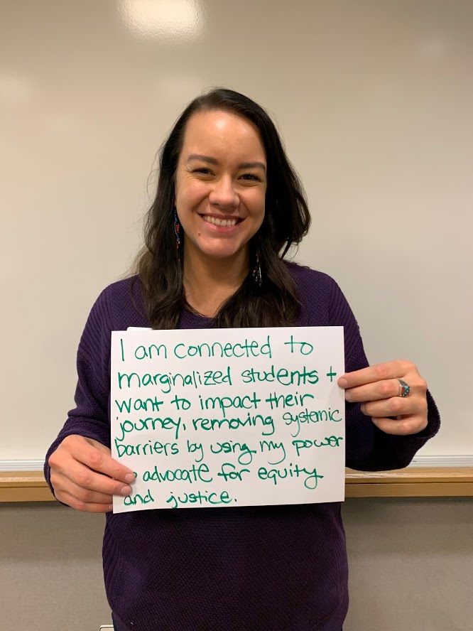 A picture of Rachael Johnson holding a sign that articulates her commitment to helping students.