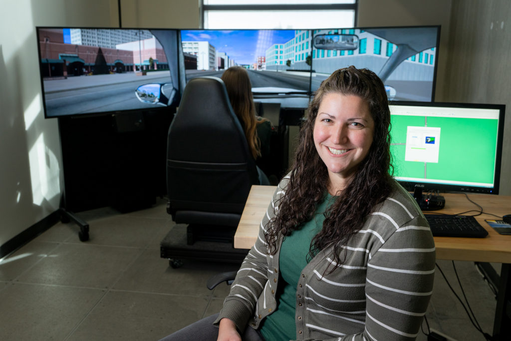 Erika Miller, Assistant Professor in Systems Engineering, works with a test student on a drive simulator.