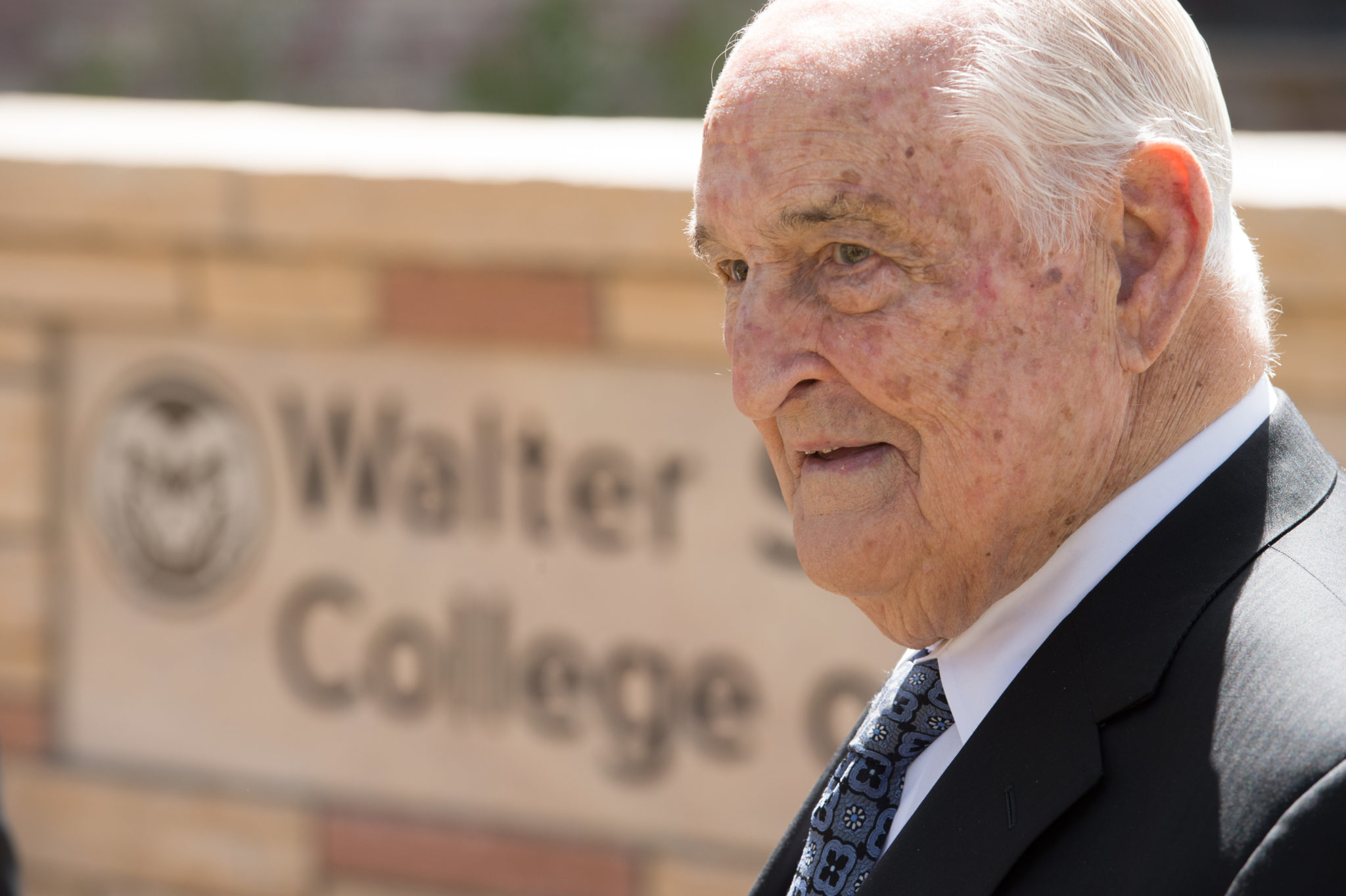 Walter Scott, Jr. in front of Walter Scott, Jr. College of Engineering sign at CSU