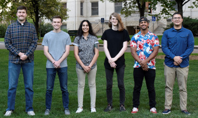 A group of students standing on a lawn.