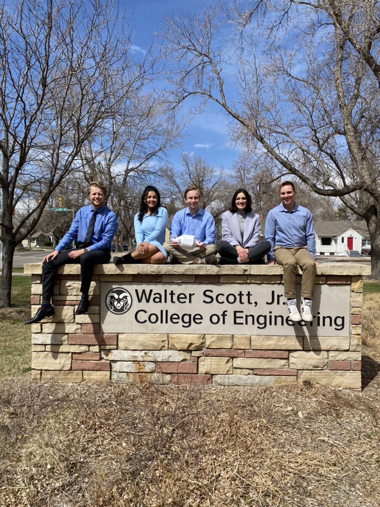 Students sitting on the Walter Scott, Jr. sign