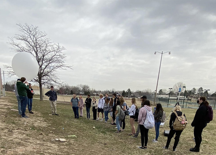 Photo showing CSU graduate students demonstrating weather balloon to Loveland High School students.