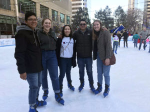 RWB members pose with two Salvadoran students on ice skates at a city rink.