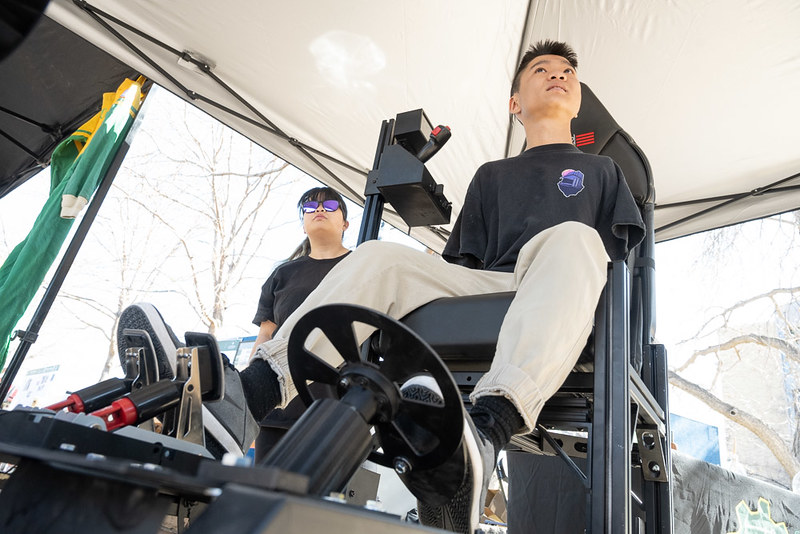 Jian Cohen, business student, testing out a driving simulator on the LSC plaza, April 24, 2023 at E-Days. (Credit: John Eisele/CSU)