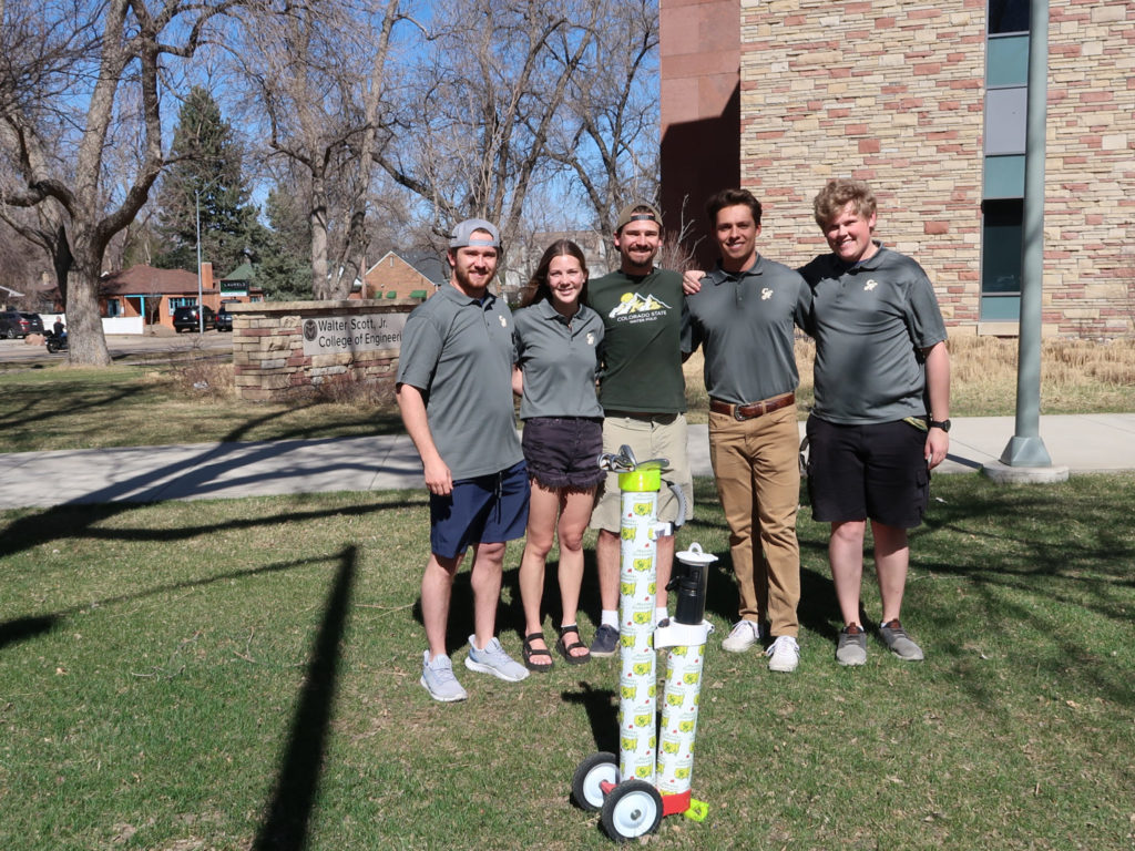 Members of the Course Rover team pose on the lawn outside the Scott Bioengineering Building with their 3D-printed golf bag.