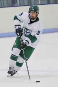 Vickers skating forward with the puck in his #9 CSU Hockey uniform