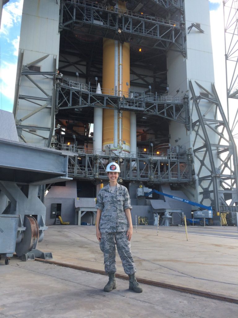 Photo of Laura Duffy, Ph.D. graduate 2023, CSU Department of Systems Engineering, standing in front of a rocket assembly.