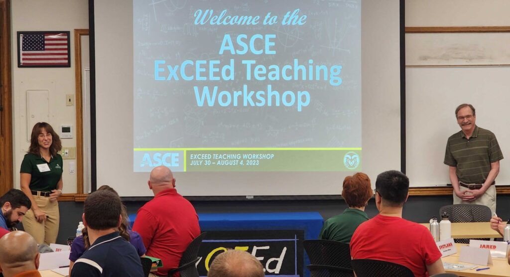 Omu-Ozbek and Shackleford stand on either side of a projection screen bearing the text, "Welcome to the ASCE ExCEEd Teaching Workshop." In the foreground, workshop participants look on.