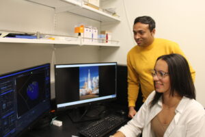 Ghosh and a female student view a computer together in a laboratory setting.