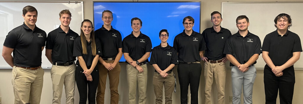 Casual indoor group photo of the members of the Ram Launch Initiative club wearing matching polo shirts with the club name and CSU Ram logo.
