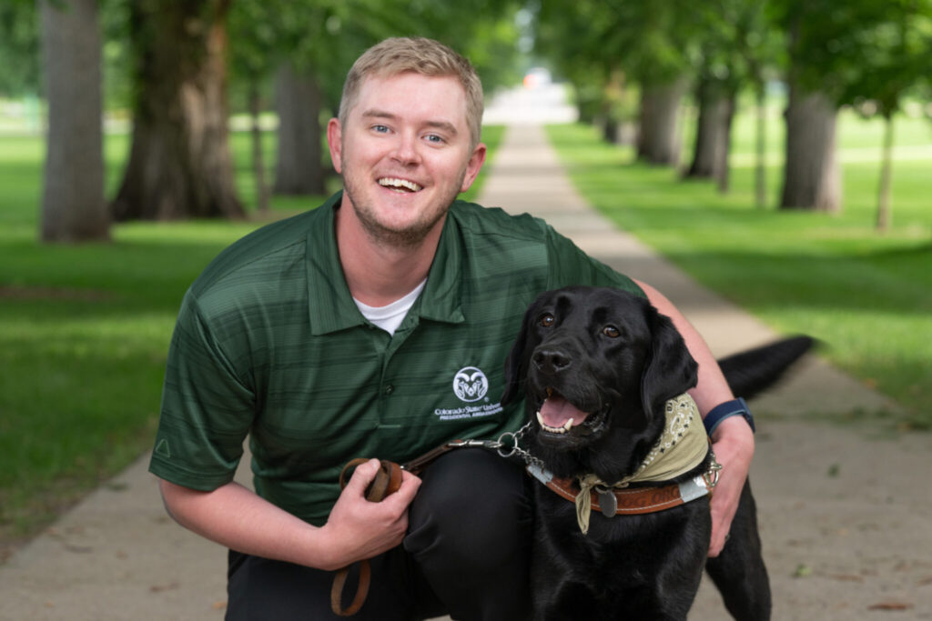 A picture of environmental engineering student Robert Lamm and his guide dog, Fletcher on the Oval.