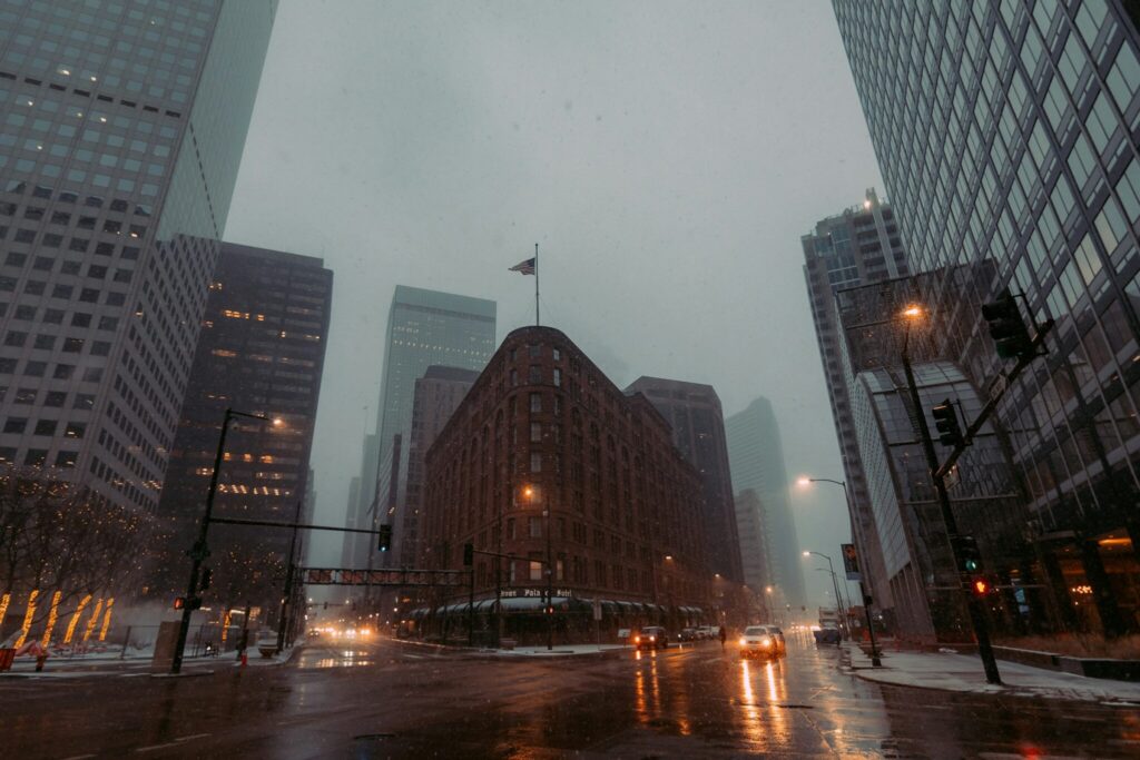 A street-level view of the buildings of downtown Denver during a rainstorm