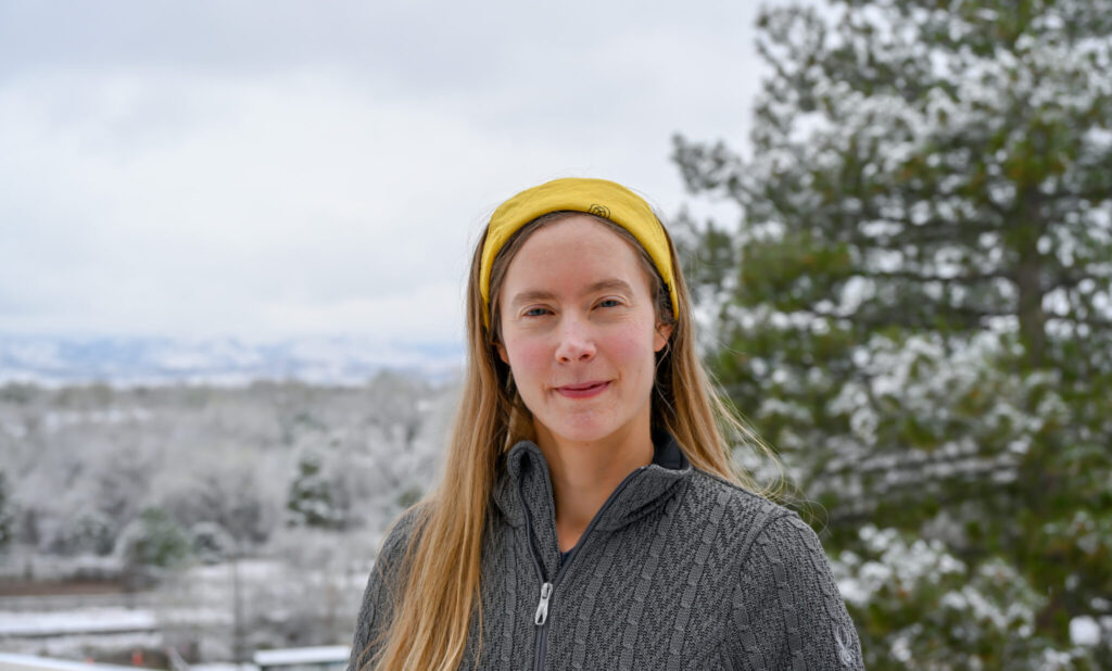 Casual outdoor portrait of Anna Hodshire with snowy city trees and foothills in the background.
