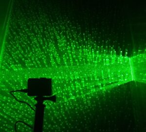 Green lasers light up a container of water to reveal tiny particles and their movement around objects.