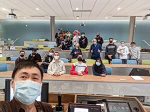 Teacher and college students in face masks pose for selfie.